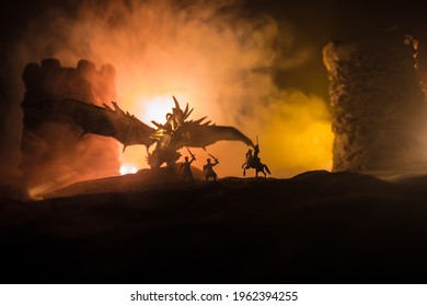 龍在夜間攻擊中世紀城堡的幻想戰鬥場景。龍與英雄戰士之間的戰鬥。創意餐桌裝飾。選擇性焦點