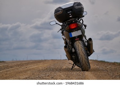 Enduro motorcykelrejsende alene under en blå himmel med hvide skyer.