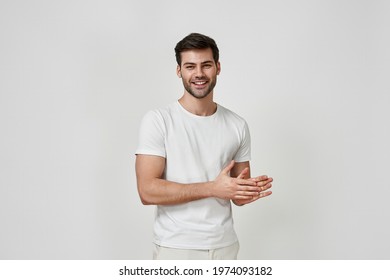 Cheerful man in studio. Portrait of a handsome bearded man in t-shirt smiling while standing against grey background. People lifestyle concept