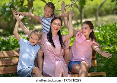 幸せな母と公園のベンチに座っている 3 人の貴重な子供たち。夏の日に都市公園で時間を過ごし、冗談を言う大家族。コンセプトが大好きです。