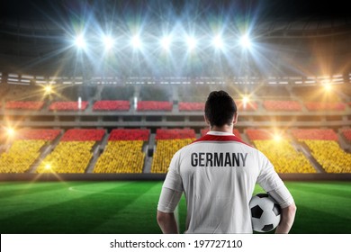 Germany football player holding ball against stadium full of germany football fans