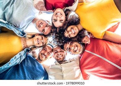 輪になってカメラに微笑む若者の多民族グループ – 一緒にハグを楽しんでいる幸せな多様な友人 – ローアングルビュー