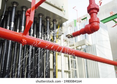 化学プラントの緊急時の消火システムの安全性テストの一環として、電源トランスの消火ホース リール ノズル スプリンクラー システムから流れる水。