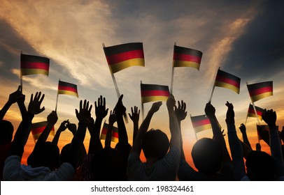 Silhouettes of People Holding the Flag of Germany 