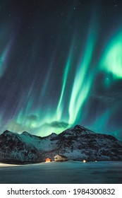 Fantástica aurora boreal verde, aurora boreal con estrellas brillando en una montaña nevada en el cielo nocturno en invierno en las islas Lofoten, Noruega
