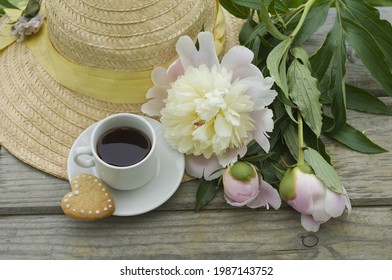 beautiful pink peonies, a cup of coffee, heart-shaped cookies, a straw hat. romantic breakfast. summer background, postcard