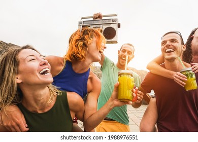 Fröhliche Freunde haben Spaß beim Musikhören mit einer alten Boombox im Freien am Strand – Fokus auf dem Gesicht des Mannes rechts.