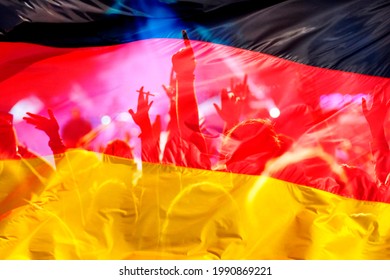 football fans supporting Germany - crowd celebrating in stadium with raised hands against Germany flag