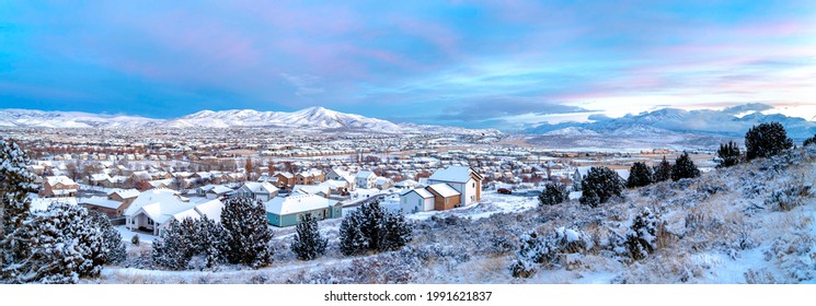 Una vista del valle y las casas con las montañas y el cielo azul como fondo. Foto de alta calidad de casas en el valle cubiertas de nieve.