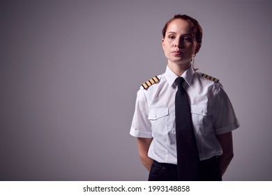 無地の背景に対して深刻な若い女性航空会社のパイロットのスタジオ ポートレート