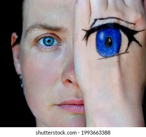 Portrait of a woman with blue eyes. Anime eye drawn on the palm. A face covered by a hand. 