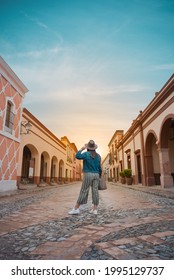 Touristin steht mitten auf der Straße einer magischen Stadt, der Stadt La Peña del Bernal in Querétaro, Mexiko, mit Sonnenuntergang davor, Sommertag