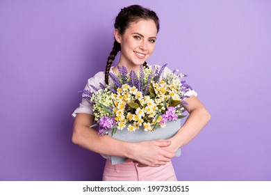 Foto de una encantadora dama alegre que sostiene una caja de flores silvestres con una sonrisa dentuda aislada en un fondo de color violeta