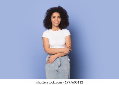 Retrato de una feliz mujer afroamericana milenaria con ropa informal aislada en un estudio azul. Sonriente joven mujer de raza mixta moderna o actriz pose disparar. Concepto de diversidad.