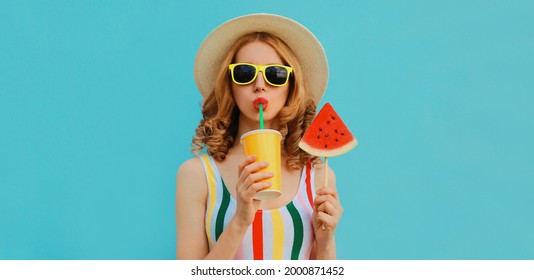Zomer kleurrijk portret van mooie jonge vrouw die sap drinkt met lolly of ijs gevormd plakje watermeloen met een strohoed op blauwe achtergrond