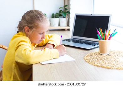 家で宿題をしている白人の女子高生は、ノートに書いています。ラップトップを持つ 10 ～ 11 歳の女の子。ホームスクーリング、eラーニング。学校に戻る。窓際の居心地の良い職場。