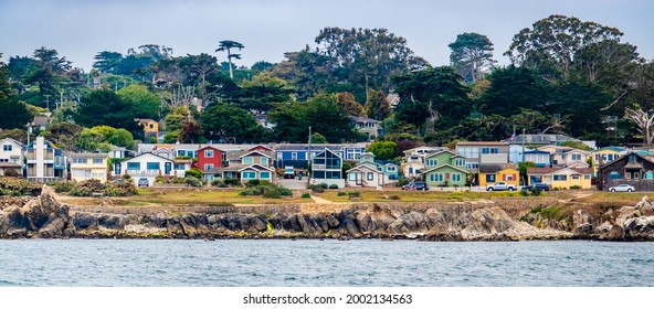Houses in Pacific Grove, California (in Monterey County) overlook the rocky coastline, as viewed from a passing boat.