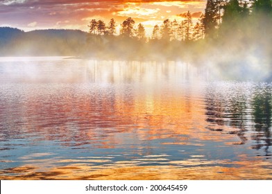 Jezero s plavajočo meglo ob sončnem zahodu, Finska.