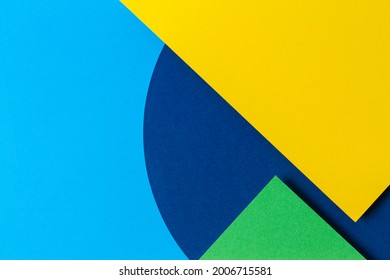 抽象的な色紙テクスチャ背景。ライトブルー、ネイビー、グリーン、イエローの最小限の幾何学的形状とライン