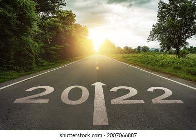Año nuevo 2022 o concepto sencillo. Texto 2022 escrito en la carretera en medio de la carretera asfaltada al atardecer. Concepto de planificación y desafío, estrategia empresarial, oportunidad, esperanza, nuevo cambio de vida