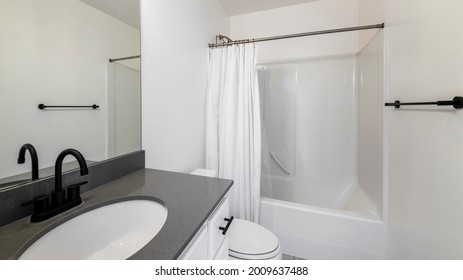 Interior de baño Pano con accesorios negros y bañera de ducha de una pieza con cortina de ducha blanca
