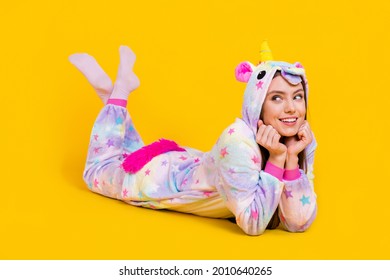Portrait of attractive cheerful girl wearing funny clothes lying good mood isolated over bright yellow color background