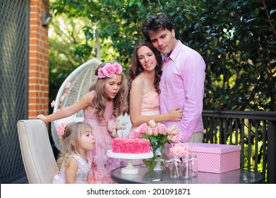Portret de familie - tatăl, mama și copiii sărbătoresc petrecerea La mulți ani în aer liber
