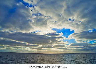 Sonnenstrahlen durchdringen dunkle Wolken. Das unvorhersehbare Drama des Himmels. Ein Blick von einem touristischen Kreuzfahrtschiff, das im Nordpazifik segelt. Juni 2019