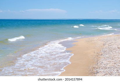Golven op de zanderige kust zijn een mooie zomerse achtergrond. Ontwerp van de achtergrond, foto wallpapers, covers, screensavers.