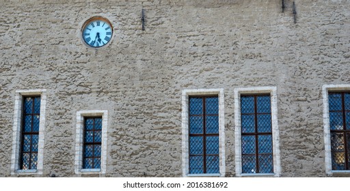 Fassade eines alten Gebäudes mit Fenstern und einer alten Uhr. Foto in hoher Qualität