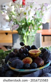 トルコギキョウ プレーリー リンドウの花、ブドウ、イチジク、プラムのある静物。テーブルの上の夏の果物と花。フルーツ テクスチャをクローズ アップ。新鮮なコンセプトを食べる。