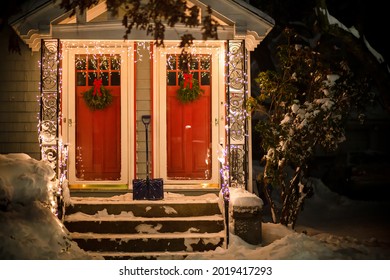 La entrada de la casa con hermosas luces navideñas y la pala. Navidad blanca nevada. Copie el espacio.