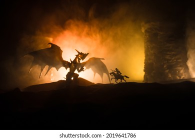 龍在夜間攻擊中世紀城堡的幻想戰鬥場景。龍與英雄戰士之間的戰鬥。創意餐桌裝飾。選擇性焦點
