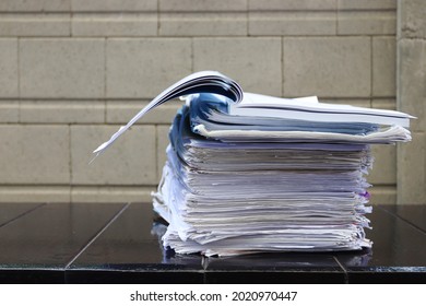 Stack of unfinished business papers  on dark background, selective focus. Work from home concept.