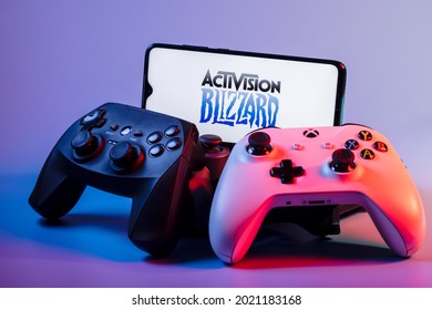 Kazan, Russia - August 7, 2021:  Activision Blizzard, Inc. is an American video game holding company. A smartphone with the Activision Blizzard logo on the screen on the pile of the gamepads.