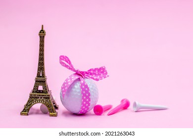 Golfbal met roze lint en Eiffeltoren op roze background
