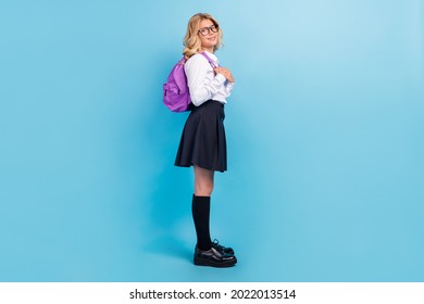 肯定的な女子高生のプロフィール写真はバックパック白いシャツ ストッキング スカート靴分離青色背景を着用します。