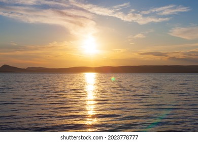 Sommerlandschaft des Sonnenuntergangs auf dem See mit Sonneneruption und Sonnenblendung auf dem Wasser