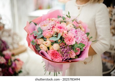 Toller Blumenstrauß aus rosafarbener Chrysantheme, Hortensie und Rosen, eingewickelt in Papier in Frauenhänden. Konzept des Blumenladens. Schöner frischer Blumenstrauß.
