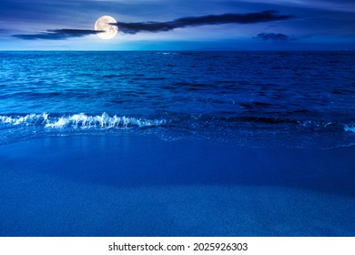 Ruhige Morgenlandschaft am Meer. Leerer Sandstrand im Vollmondlicht. Entspannungs- und Sommerferienkonzept. Wolken am Himmel bei Nacht
