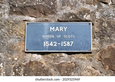 Kovový nápis 'Mary Queen of Scots 1542-1587' na staré kamenné zdi