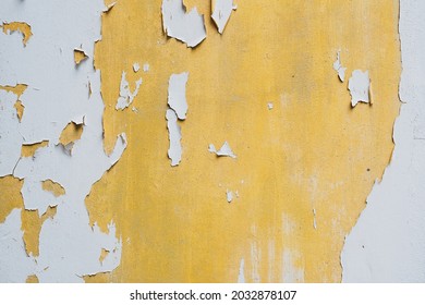 La superficie de textura de color blanco y amarillo se desvanece, se despega y agrieta el fondo dañado de la pared