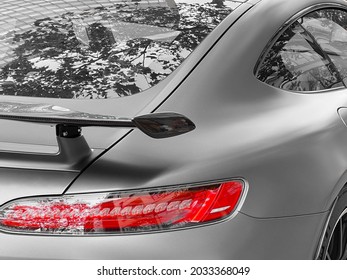 車のガラスに映る樹冠。スポーツカーのバックライト。外装のクローズ アップの詳細。車の詳細