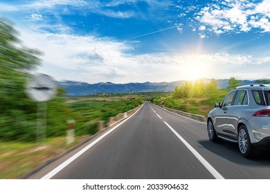 Grey car on a scenic road. Car on the road surrounded by a magnificent natural landscape.