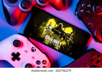 Kazan, Russia - September 07, 2021: Call of Duty: Mobile is a free-to-play shooter game. A smartphone with the frame from Call of Duty on the screen surrounded by gamepads.