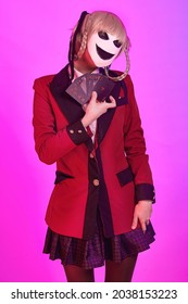 Girl with playing cards and mask in hands