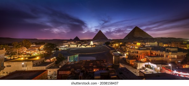Las pirámides y la esfinge en las luces nocturnas, Giza, Egipto