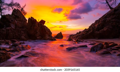 Lange blootstellingsbeeld van dramatisch hemelzeegezicht met rots in de achtergrond van het zonsonderganglandschap Verbazend licht aardlandschap.