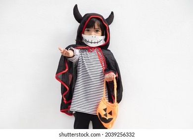 Asian little girl in a Halloween costume in a medical mask . Halloween with safety measures from Covid-19