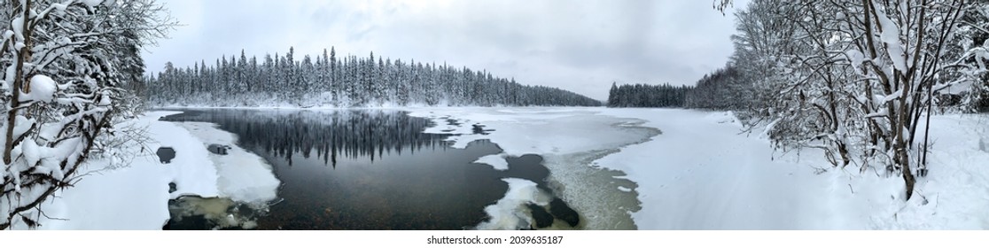 Panorama raksasa sungai es yang tertutup salju di antara hutan taiga beku di musim dingin